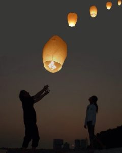 couple releasing lanterns in the night sky